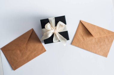 Noel hediyeleri ve hediye kutuları, tahta bir masaya sarılmış zarf, köknar ağacı dalları ve süslemeler, üst manzara. Düz konum, metin için boşluk kopyala.