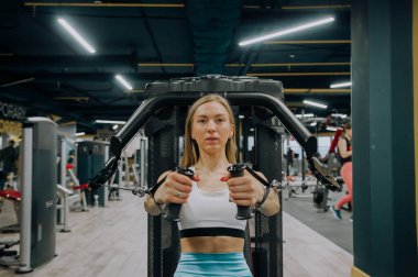 Atletik kadınların göğüs bir simülatör spor salonunda eğitim