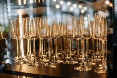 Seçici bir odak noktasında boş şarap kadehleri. Sıcak ışıklı çatı katı restoranında şarap bardakları. Barda ve restoranda içecek çok şey var..