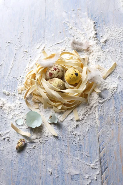 Italian pasta with quail eggs for Easter on a wooden surface — Stock Photo, Image