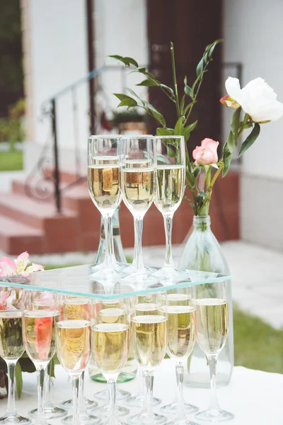 Glasses with champagne and beautiful flowers — Stock Photo, Image