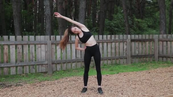 Frau trainiert in der Natur und macht Oberkörperbeugen. Fühlt plötzlich einen starken Schmerz im Rücken — Stockvideo