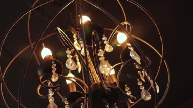 Tavanda büyük yuvarlak dekoratif avize. Kamera hareket ediyor.