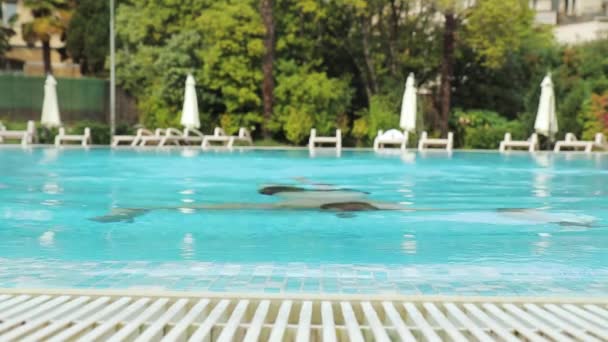 Молодий чоловік борода виникає в готельному басейні в окулярах для плавання — стокове відео