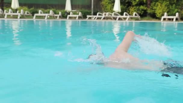 Młody człowiek broda pływa w hotelowym basenie w goglach kąpielowych — Wideo stockowe