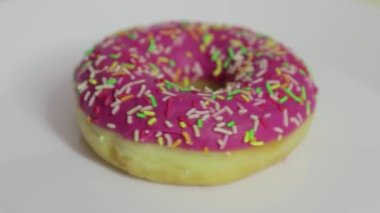 Pembe kremalı donut beyaz arkaplanda dönüyor