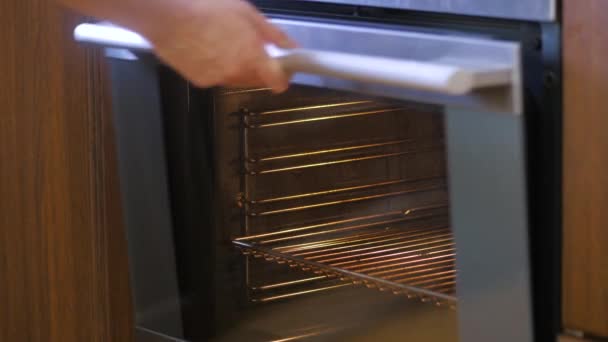 手把烤好的馅饼放在烤箱里，关上了门 — 图库视频影像