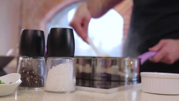 Chef mezcla la comida con una espátula de cocina en una sartén — Vídeos de Stock