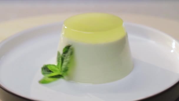 Panna cotta com limão e folha de hortelã em uma placa branca — Vídeo de Stock