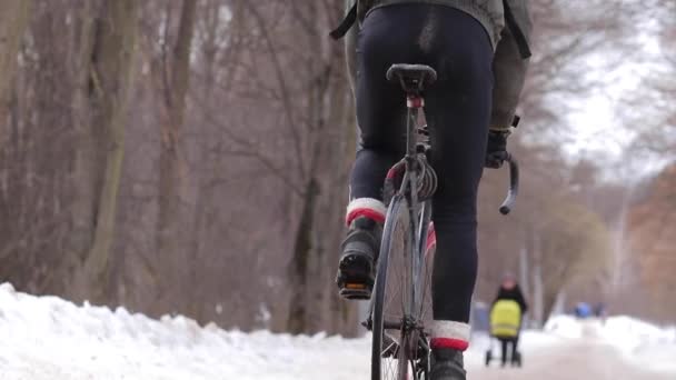 Cykel kurir ben trampar en cykel med en kylväska på baksidan på vintern — Stockvideo