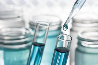 Pipet ekleyerek mavi sıvı test tüpü yakın çekim.