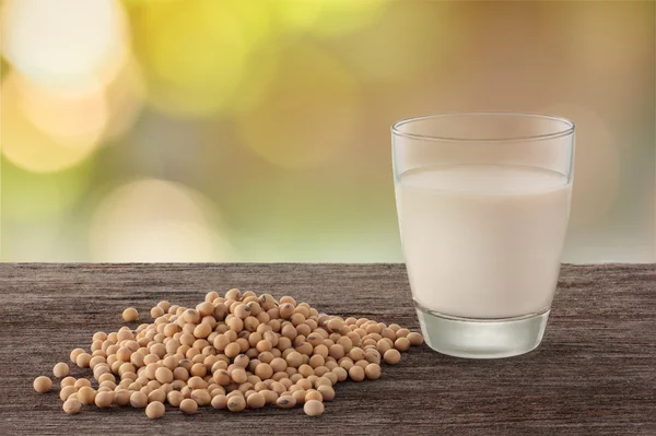 Glass of soy milk and soybean in garden background. — Stock Photo, Image