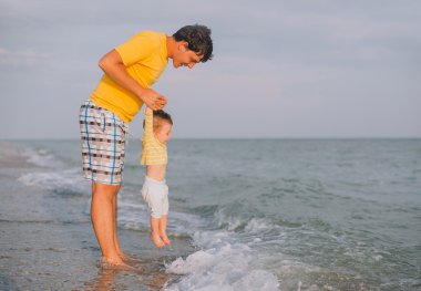 onun bebeği ile deniz plajda oynayan genç Baba