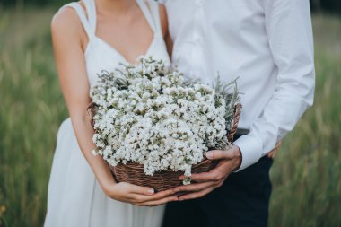 Adam ve sepet çiçekli tutan kız 