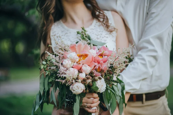 Пара держит свадебный букет — стоковое фото