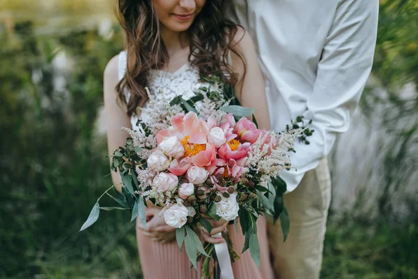 Couple holding wedding bouquet — Stock Photo, Image