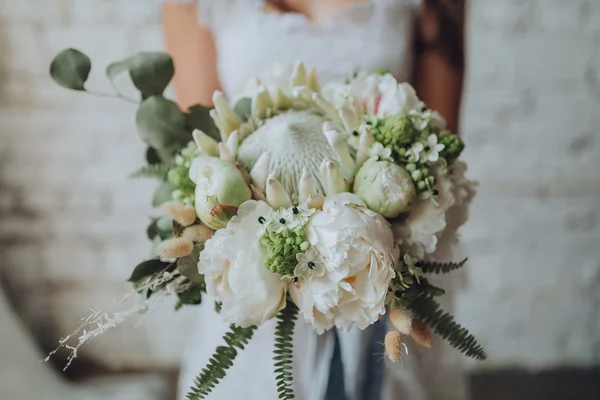 Fille en robe de mariée tenant bouquet — Photo