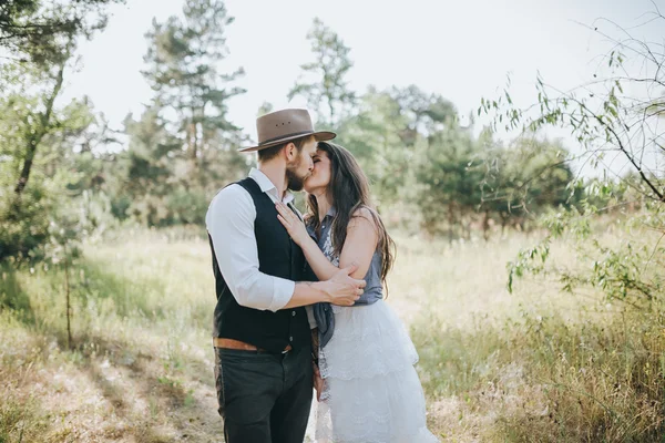 Žena ve svatebních šatech a muž v lese — Stock fotografie