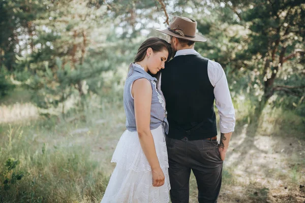 Žena ve svatebních šatech a muž v lese — Stock fotografie