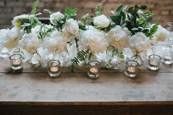 White peonies in glass bottles — Stock Photo, Image