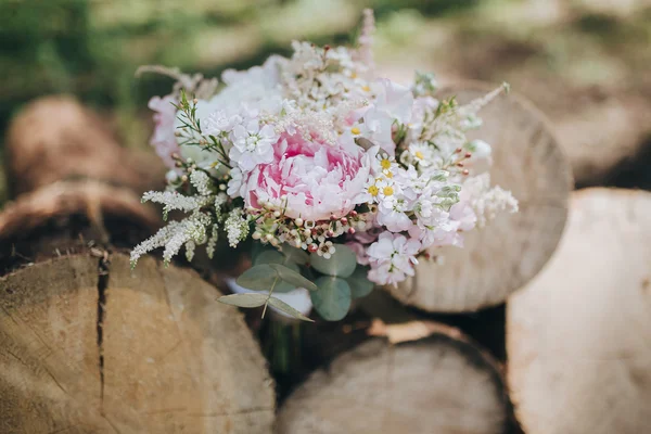 Ramo de flores silvestres en troncos — Foto de Stock