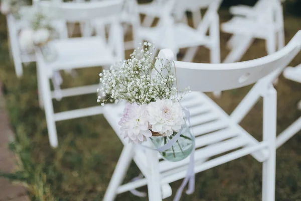 Weiße Stühle mit Blumen dekoriert — Stockfoto