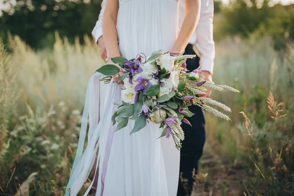 Sposo e sposa tenendo bouquet da sposa — Foto Stock