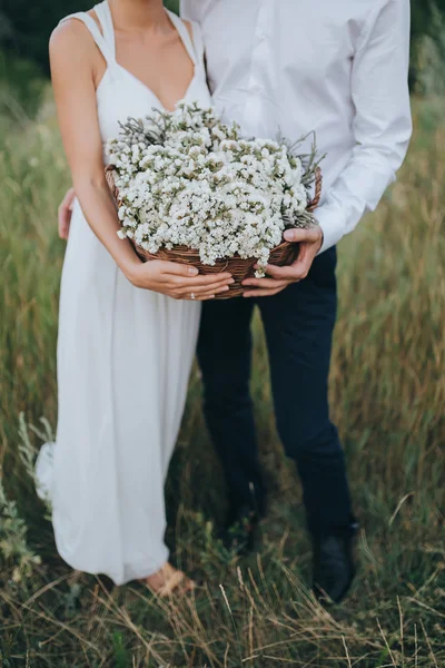 Guy e menina segurando cesta com flores — Fotografia de Stock