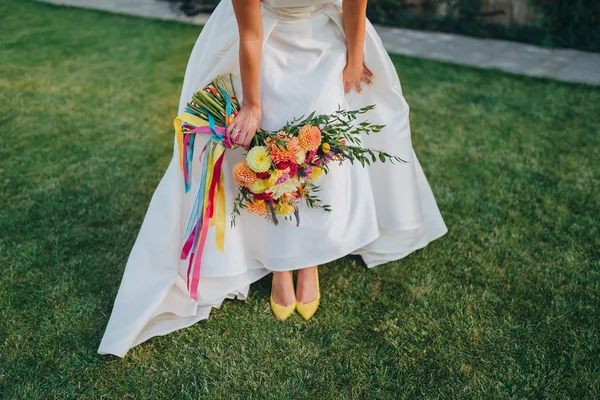 Bride in white dress holding bouquet — Stock Photo, Image