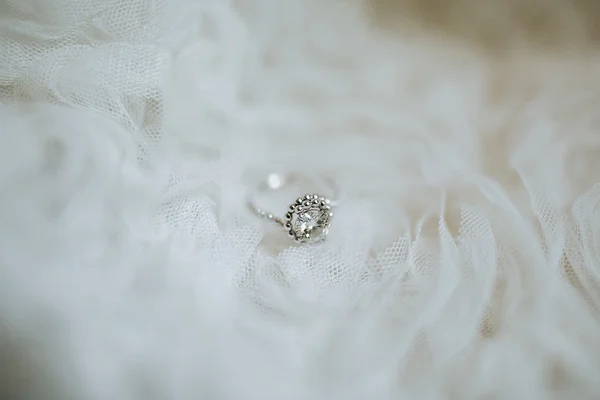 Zásnubní prsten na bílé tkanině — Stock fotografie