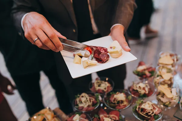 Invitado en la fiesta con aperitivo en el plato —  Fotos de Stock