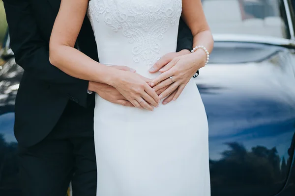 Groom hugging bride in white dress — Stock Photo, Image