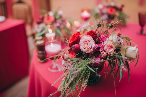 Composición de flores rojas y rosas en la mesa — Foto de Stock