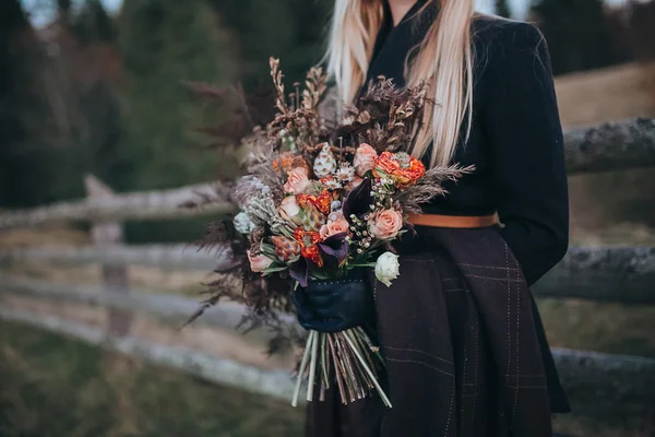 Ragazza in abito scuro tenendo bouquet — Foto Stock