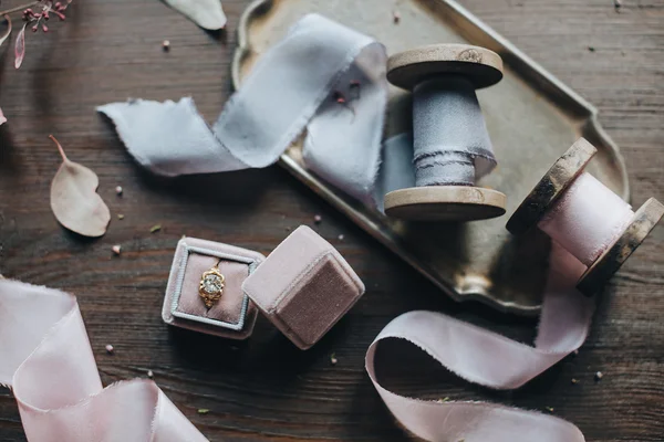 Шелковые ленты и кольцо в коробке на столе — стоковое фото