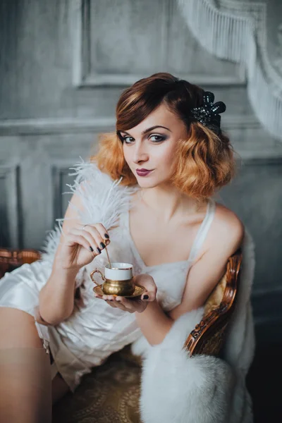 Girl in corset and stockings drinking coffee — Stock Photo, Image