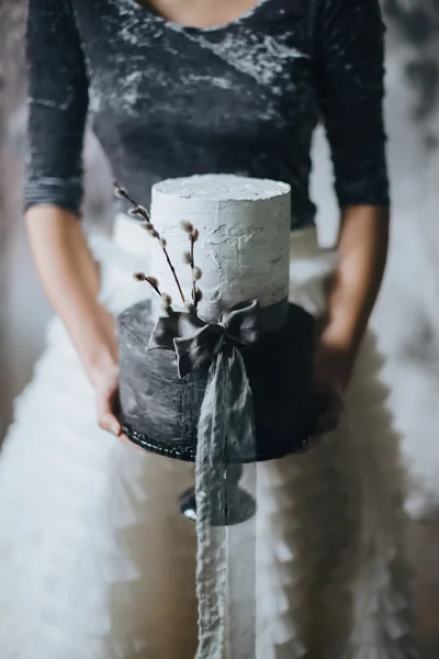 Gelin düğün pastasını tutuyor