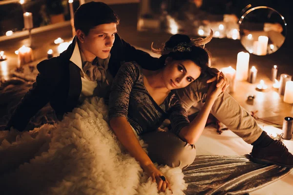 Mooie bruid en bruidegom onder kaarsen — Stockfoto