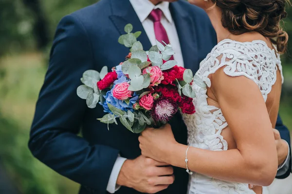 Brudgummen och bruden hålla bröllop bukett — Stockfoto