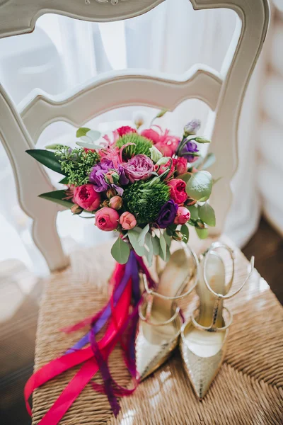 Wedding bouquet and bridal shoes on chair — Stock Photo, Image