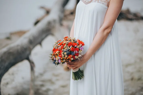 Noiva em vestido branco segurando buquê — Fotografia de Stock