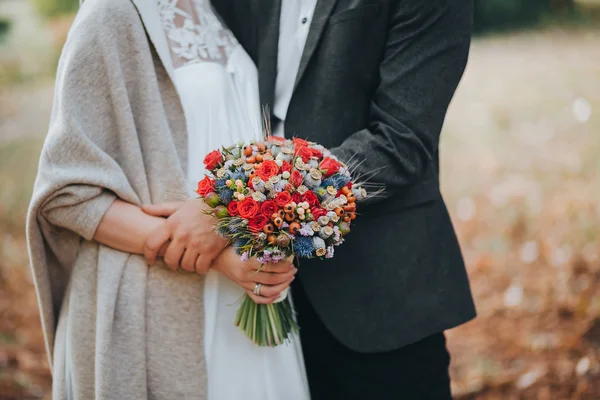 Groom and bride holding wedding bouquet — Stock Photo, Image