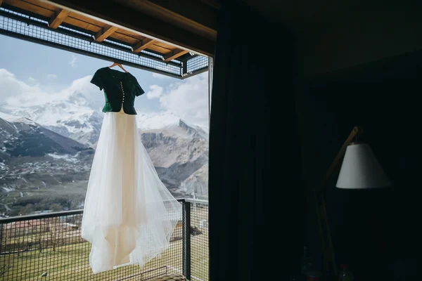 Винтажное свадебное платье висит на балконе на фоне sn — стоковое фото
