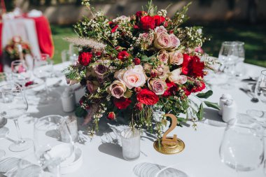 Düğün. Ziyafet. Tahıl. Sanat. Masa örtüsü renklerle Marsala Ziyafet masada çiçek ve yeşillik, çatal bıçak takımı ve mumlar bileşimi olduğunu