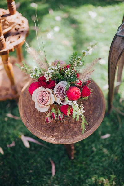 結婚式。装飾。穀物。アートワーク。芝生の上に立つビンテージ木製のテーブル、テーブルの上に花と緑の組成 — ストック写真