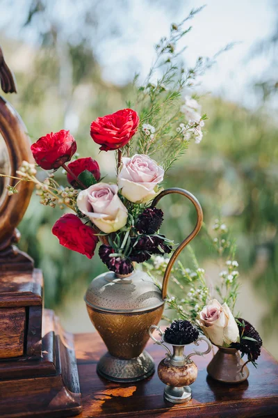 Pernikahan. Dekorasi. Biji-bijian. Karya seni. Di halaman berdiri meja kayu vintage, di atas meja adalah komposisi bunga dan hijau — Stok Foto