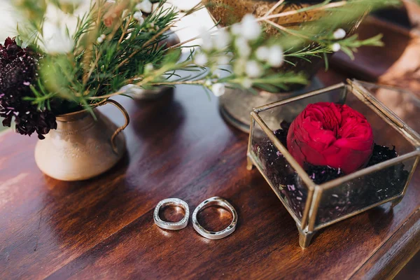 結婚式。結婚指輪。装飾。アートワーク。穀物。式のボックスの横に木製のテーブルに横に新郎・新婦の結婚指輪 — ストック写真