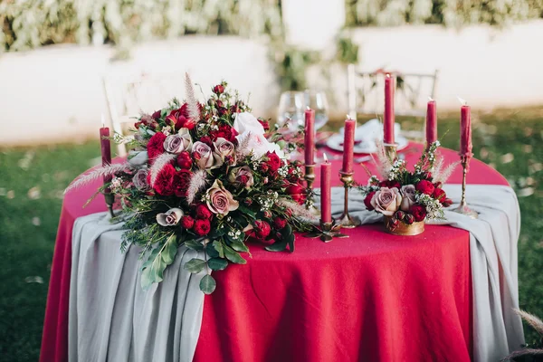 Casamento. Banquete. Grão. Obra. Na mesa do banquete com toalha de mesa cores Marsala, é a composição de flores e vegetação, talheres e velas — Fotografia de Stock
