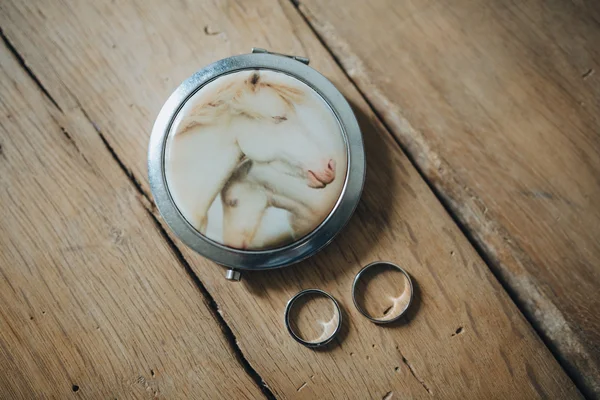 Обручальные кольца жениха и невесты, лежащие на деревянном столе — стоковое фото
