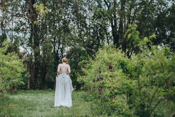 Wedding. The bride in a dress standing in a green garden
